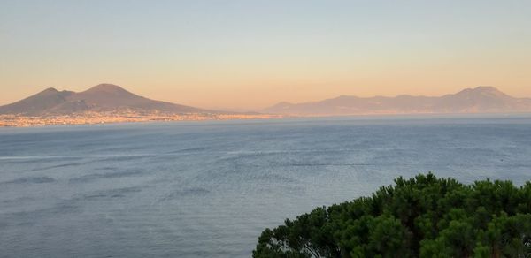 Scenic view of sea and mountains against clear sky