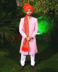 Portrait of indian groom standing in lawn at night