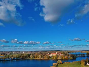 Scenic view of lake by buildings against blue sky