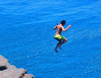 Woman jumping in swimming pool