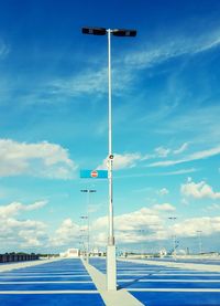 Street light on road against blue sky