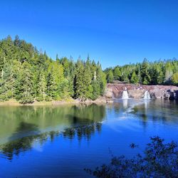 Scenic view of lake against clear blue sky