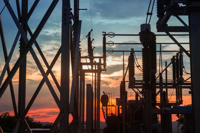 Low angle view of silhouette cranes against sky during sunset