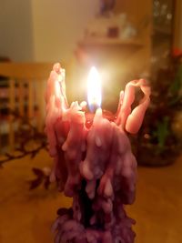 Close-up of hand holding burning candle