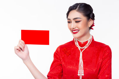 Portrait of a smiling young woman against white background