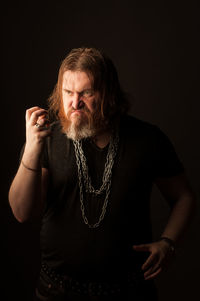 Mid adult man standing against black background