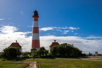 Lighthouse amidst buildings against sky