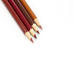 High angle view of colored pencils against white background