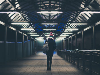 Rear view of woman standing at subway station