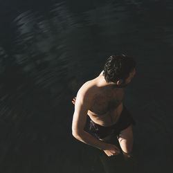 High angle view of shirtless man standing in lake at holiday villa