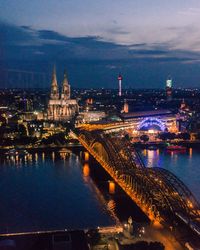 Illuminated cityscape against sky at night