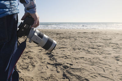 Photographer ready to take horizon photos on the beach. professional travel photography jobs.