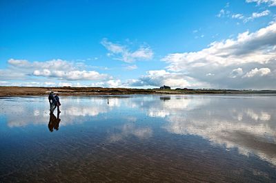 People on lake against sky