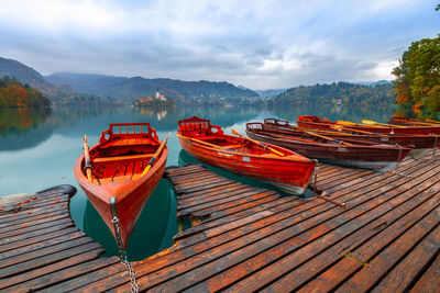 Boats moored on lake against sky