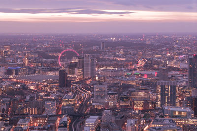 Aerial view of illuminated city buildings at sunset