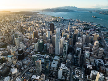 Aerial view of downtown skyscrapers at sunset. sea bay with islands and hilly landscape in