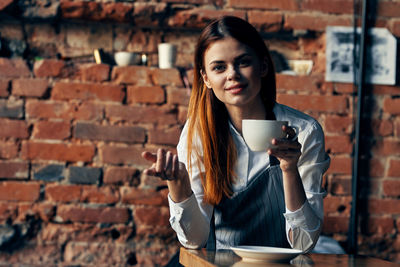 Portrait of woman holding coffee cup