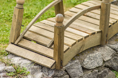 High angle view of wooden bench on rock in garden