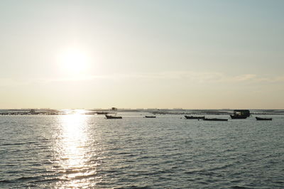 Boats sailing in sea against sky during sunset