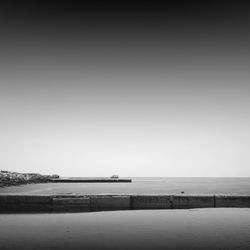 Pier at beach against sky