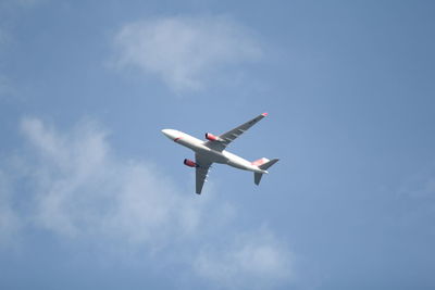 Low angle view of airplane flying against sky