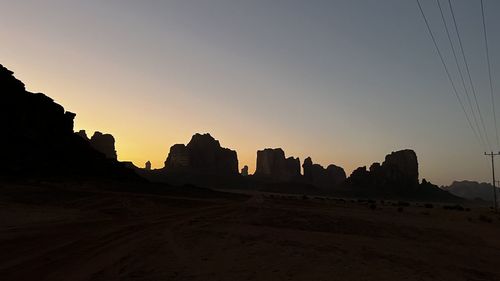 Silhouette landscape against clear sky during sunset