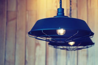 Close-up of illuminated light bulb hanging on wall