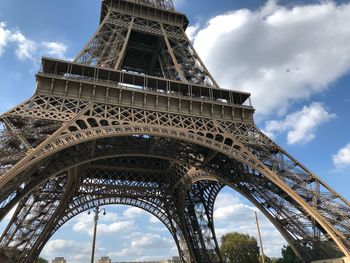 Low angle view of eiffel tower against cloudy sky