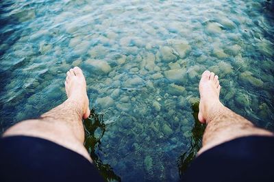 Low section of man sitting on water