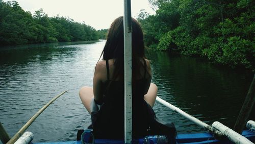 Rear view of woman in boat sailing on river