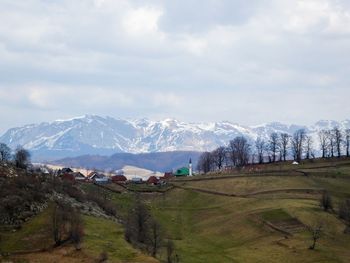 Scenic view of field and mountains against sky