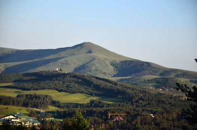 Mountains, hills, valleys with small houses in sunlight