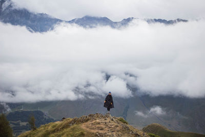 Scenic view of woman on mountain against sky