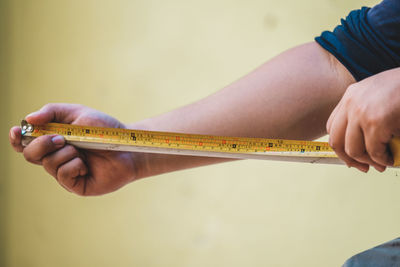 Cropped hands of carpenter holding tape measure