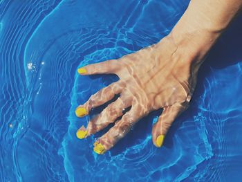 High angle view of person hand in swimming pool