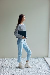 Young woman standing against wall