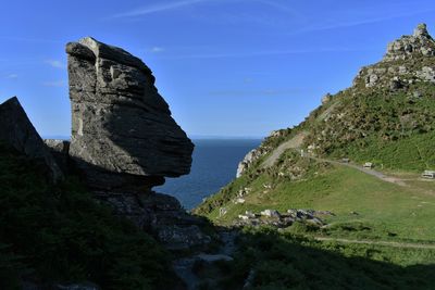 Rock formations by sea against sky