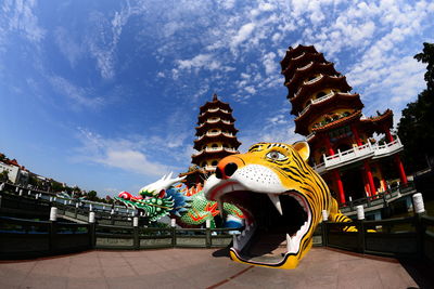 Low angle view of statue in temple against cloudy sky