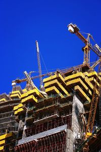 Low angle view of crane against clear sky