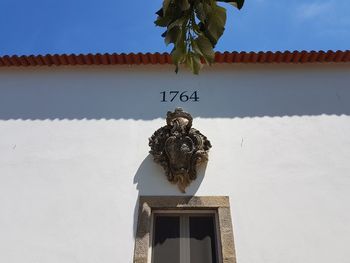 Low angle view of statue against building against sky