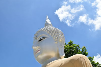 Low angle view of buddha statue against sky