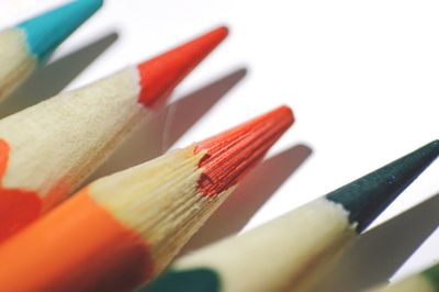 Close-up of colored pencils over white background