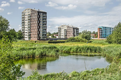 Scenic view of lake by buildings against sky