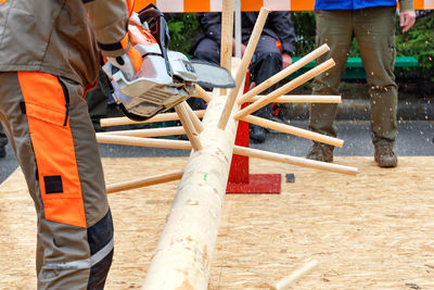Lumberjack competition, a worker dexterously demonstrates the ability to handle a chainsaw.