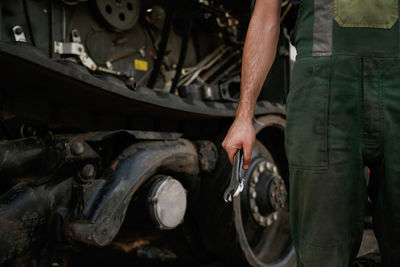 Midsection of man repairing car
