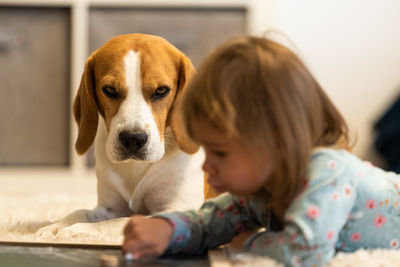 Cute girl with dog relaxing on floor at home