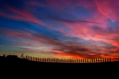 Silhouette of city against sky during sunset