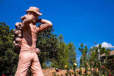 Low section of person standing against blue sky