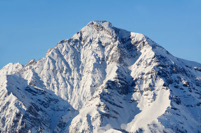 Panoramic view of snowcapped mountains against clear blue sky