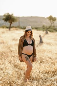 Young woman wearing hat standing on field